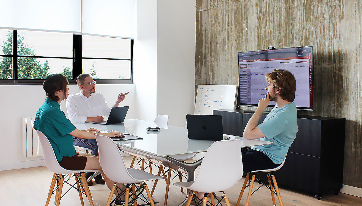 An image of a group of professionals gathered around, discussing ideas during a team meeting.